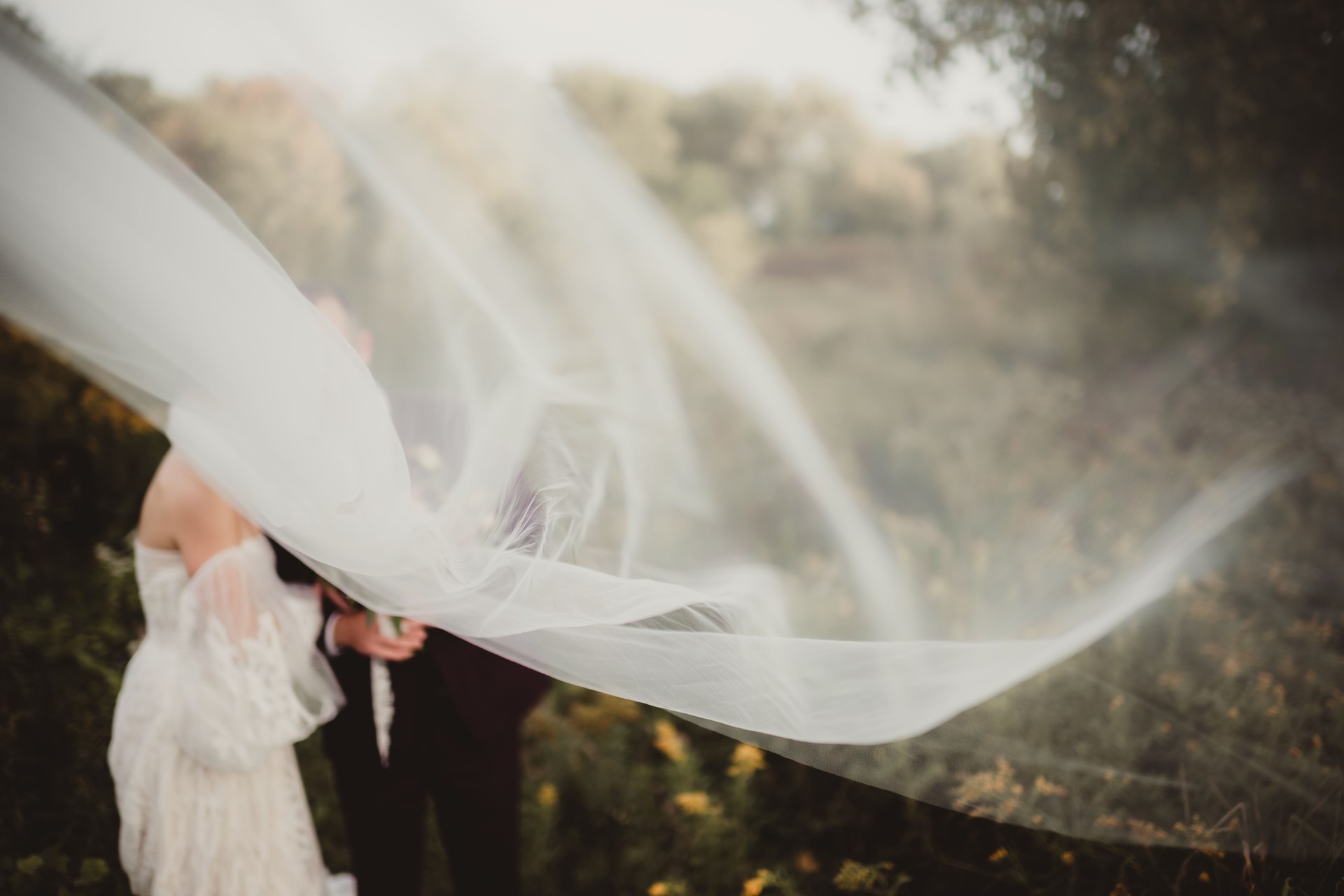 Bride and groom with blowing veil