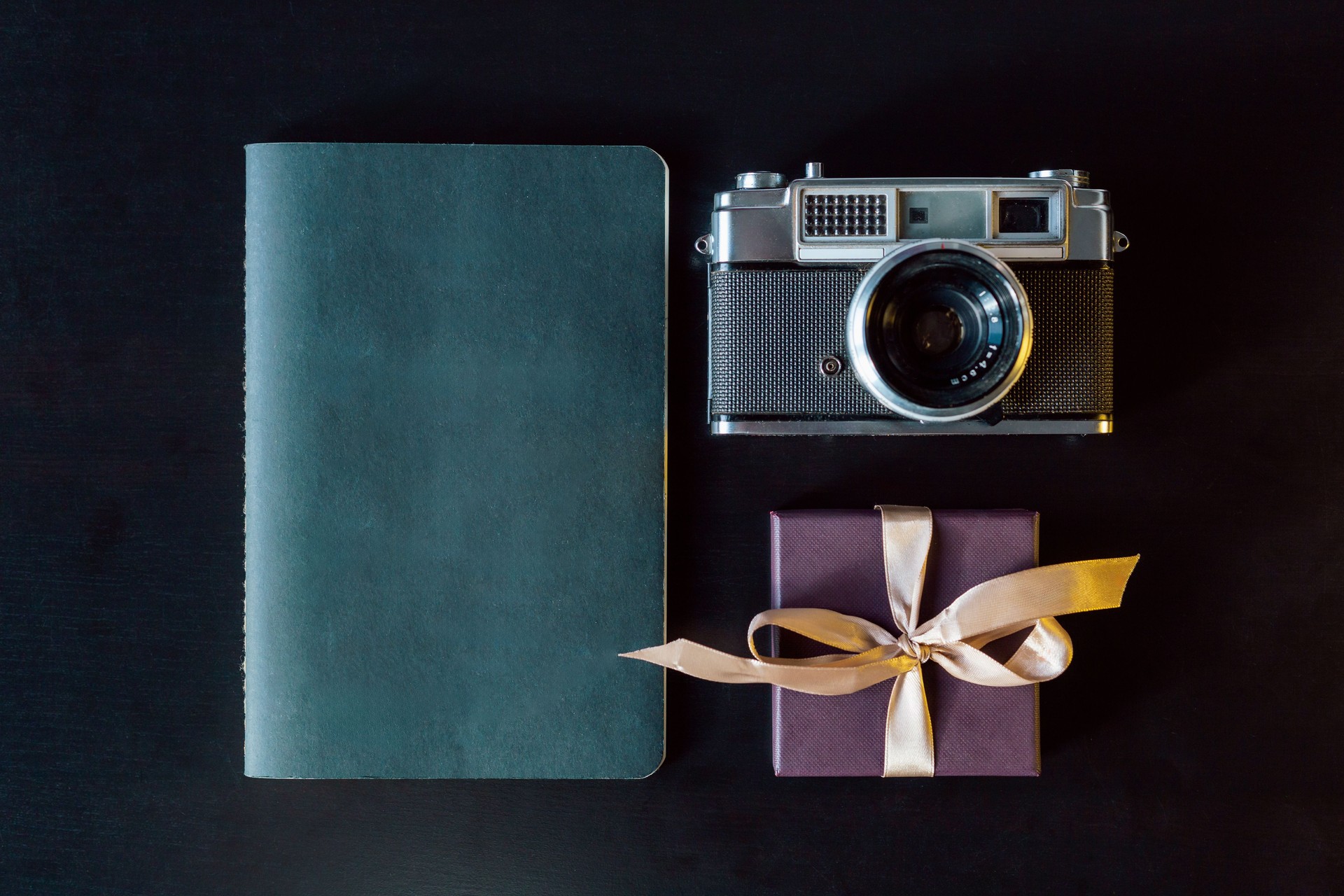 Vintage Camera With Notebook and Gift Box on Dark Surface