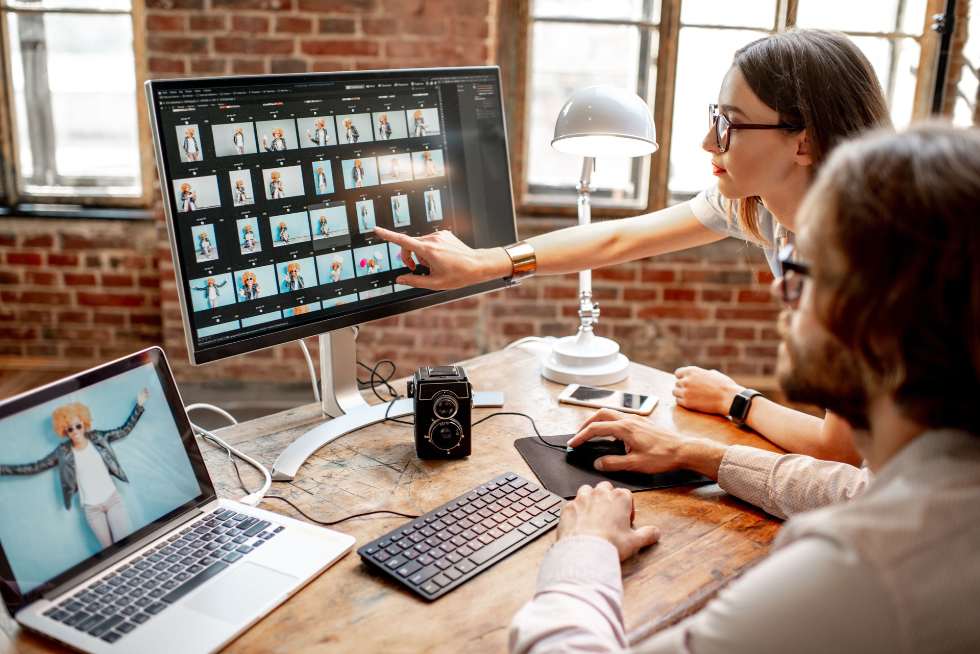 Couple of photographers working on computers in the studio